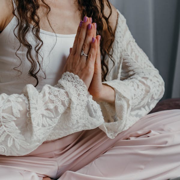 A woman sitting cross-legged indoors, practicing meditation and mindfulness.