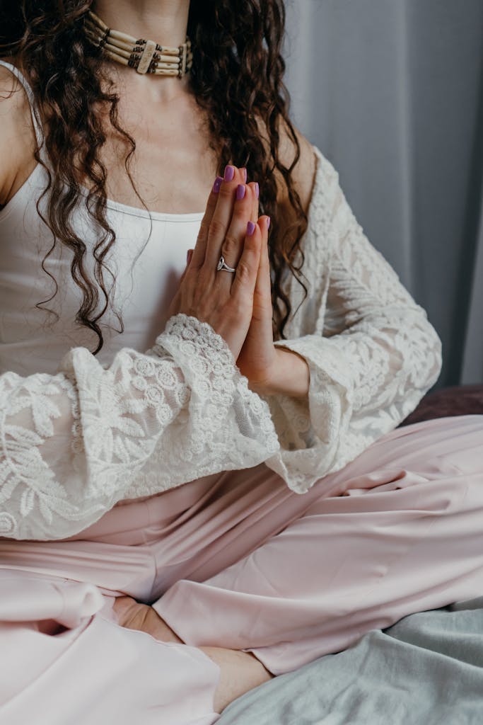 A woman sitting cross-legged indoors, practicing meditation and mindfulness.